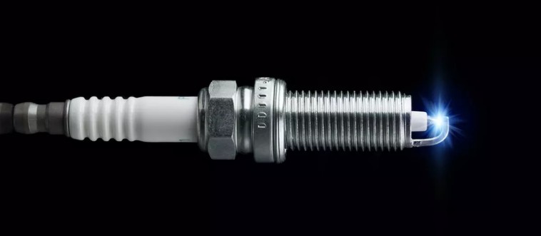 Can you identify the component that delivers the high-voltage zap to ignite the engine's fuel?
