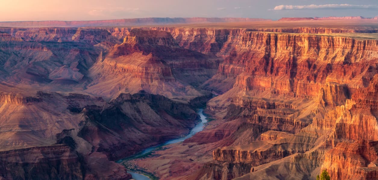Which state lays claim to the Colorado River's geological masterpiece, the Grand Canyon?